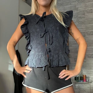 Svart blommig blus med volang och knyt - Supersöt mörkblå blus med små .