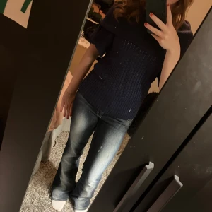 Mörkblå stickad offshoulder tröja - Säljer en mörkblå stickad tröja med offshoulder-design och korta ärmar. Tröjan har bred ribbad kant upptill som man kan ha lite som man vill bland annat offshoulder, stor polo eller boat neck 💗