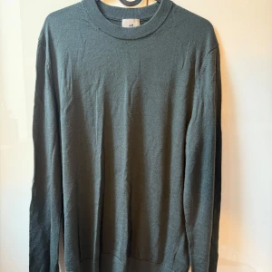 Mörkgrå stickad tröja från H&M - En enkel och stilren slim-fit mörkgrå stickad tröja från H&M. Tröjan har rund halsringning och långa ärmar, 