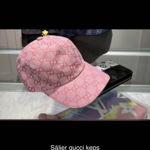 Rosa Gucci keps med monogram - Säljer en rosa keps från Gucci med klassiskt GG-monogram över hela kepsen. Kepsen har böjd skärm och justerbar baksida. Perfekt accessoar för dig som vill sticka ut med lyxig streetstyle.