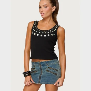 Svart linne med stora silvriga knappar - Svart ribbad linne från EDIKTED med stora silvriga knappar längs ringningen och axelbanden. Står storlek M men är som en S 