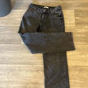 Svarta raka jeans  - Säljer ett par svarta jeans från Gina Tricot med klassisk femficksdesign och raka ben. Jeansen har medelhög midja och är tillverkade i kraftig denim med snygg tvättad finish. Perfekta för en clean och avslappnad look. Dom är använda en gång 