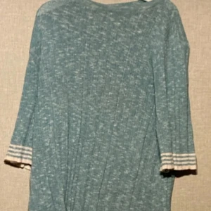 Blå ribbad klänning från Dobber XS - Snygg blåmelerad kortklänning från Dobber i storlek XS. Klänningen har ribbad struktur och trekvartsärmar med vita ränder vid ärmsluten. Perfekt för dig som gillar en chill och stilren look med lite sportig touch.