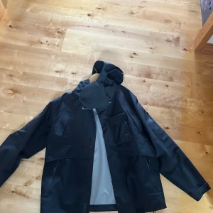 Svart Nike Travis scott vindjacka med huva - Svart Nike x Cactus Jack regnjacka. Köpt för ungefär 3 år sedan, men använd väldigt sällan. Inga flaws, däremot har jag tappat bort fleece-delen som ska va i ovandelen av jackan. Pris kan diskuteras. Har kvitto från Nike appen. 
