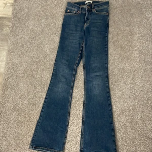  blå bootcut jeans - Snygga blå jeans från Gina tricot med klassisk bootcut-passform. Jeansen har fem fickor, låg midja och är tillverkade i slitstarkt denim. Perfekta för dig som gillar en tidlös och avslappnad stil.
