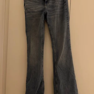 Blå bootcut jeans från H&M, strl 44 - Säljer ett par blå bootcut jeans från H&M i storlek 44. Jeansen har klassisk femficksdesign, lätt tvättad look och vida ben nertill. Perfekta för dig som gillar retrovibbar och en avslappnad stil. Materialet är mjukt denim i bomull.
