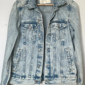 &Denim by H&M, blå, jeansjacka, Stl 36  - Blå jeansjacka med klassisk krage och knäppning fram. Jackan har två bröstfickor med knappar och två sidfickor. Den har en ljus tvätt och en rak passform. Stl 36 samt i fint skick!