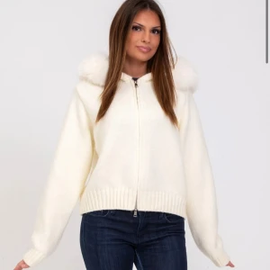 Vit stickad alessa cardigan  - Säljer min jättemysiga och trendiga alessa cardigan jacka med en avtagbar rävpälskrage med mycket hög kvalite. Säljer denna för jag ej använder den. Den är använd 1 gång och in princip ny. Nypriset är 1800. 