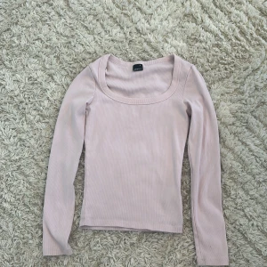 Ljusrosa ribbad långärmad topp Gina Tricot - Säljer en ljusrosa långärmad topp från Gina Tricot i storlek M. Toppen har en bred, rundad halsringning och är ribbad i materialet vilket ger en snygg och skön passform. Perfekt att styla med jeans eller kjol för en chill look.