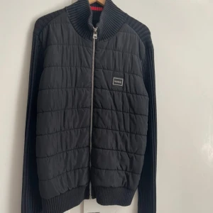 Svart cardigan från Hugo  - En cardigan från Hugo jätte fräsch men dragkedjan på sista bilden har tappat lite färg men annars helt top fräsch där med priset. Ny pris 3200 