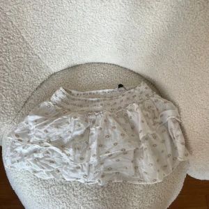 Vit och guldig volangkjol från Zara - Säljer denna superpopulära volangkjolen från Zara.🤍🤍