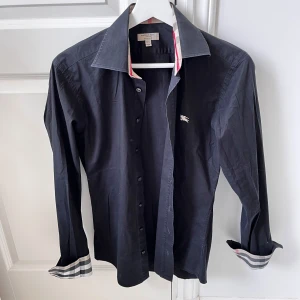 Burberry skjorta svart XS - Storlek Xs i väldigt bra skick. Inga defekter direkt förutom att den har tidigare varit använd. Modellen är 180,75 kg och är alldeles för liten på honom. ✌️