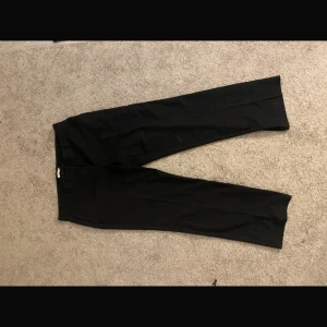 Svarta kostymbyxor från Nelly - Svarta kostymbyxor från Nelly med klassisk rak passform. 