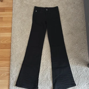 Svarta bootcut jeans Cheap Monday - Svarta bootcut jeans från Cheap Monday i modellen Booty. De har låg midja och är tillverkade i superstretchigt material för en bekväm passform. Klassisk femficksdesign och diskreta detaljer. Perfekta för dig som gillar en snygg siluett med lite utsvängda ben.