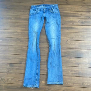 Blå bootcut jeans från Lee - Snygga blå jeans från Lee med klassisk bootcut-passform. Dem ser väldigt blå ut på bilden men det är bara ljuset, kolla 3de bilden för att se färgen mer exakt. Jeansen har fem fickor, ljus tvätt och kontrastsömmar. Tillverkade i slitstarkt denim med Lee-logga på bakfickan. Storlek W25 L33. Nypris 700.