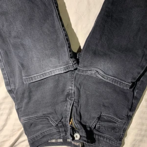 Baggy grå jeans från LAB Industries - Baggy jeans i mörkgrå tvätt från LAB Industries. Modellen har loose fit och stora fickor både fram och bak för en avslappnad vibe. Tillverkade i mjukt jeanstyg, perfekta för dig som gillar streetwear och bekväma byxor.