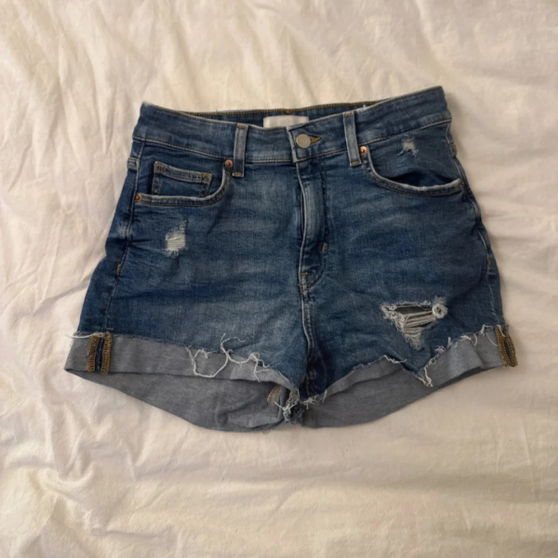 Blå jeansshorts med slitningar