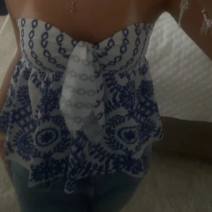 Blåvit axelbandslös topp - Snygg axelbandslös topp med knytning fram🩷(inte min bild)