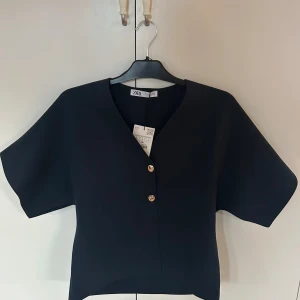 Mörkblå blus med guldknappar från Zara - Säljer denna jättefina mörkblå blus ifrån Zara. Helt slutsåld. Aldrig använd så den är i jättebra skick och prislappen är kvar på. Stolen L. Prisk kan diskuteras❤️❤️