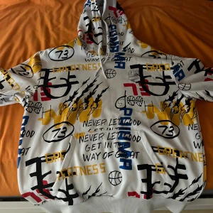 Unik Hoodie Puma Herr  - Säljer en vit hoodie från Puma med coolt grafiskt print i gult, blått, svart och rött. Tröjan har huva med snörning, känguruficka och tryck med basketbollar, klomärken och texten 'Never let good get in the way of great'. Perfekt statement-plagg för dig som gillar streetstyle. Detta hoodie har en väldigt unik stil dessutom som inte går att hitta enkelt. Jag har ej prislapp eller original förpackning eftersom jag fick det i present