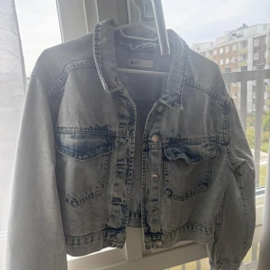 Ljusblå croppad jeansjacka från Gina tricot  - Säljer en ljusblå croppad jeansjacka från Gina Tricot. Snygg tvättad denim-look och normal passform. Perfekt att slänga över en hoodie eller t-shirt.