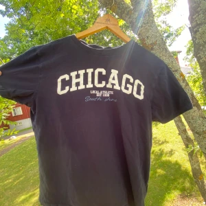 Marinblå t-shirt med tryck - Snygg marinblå t-shirt med vit CHICAGO-tryck på bröstet och mindre text under.