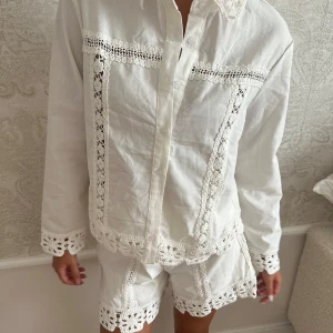 Vitt sett spetsdetaljer - oanvänt Vitt sett i linne med med långa ärmar och unika virkade spetsdetaljer på ärmslut och framstycke. lappar är kvar 