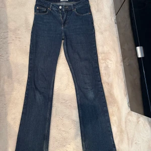 Mörkblå bootcut perfect jeans från Gina Tricot. I storlek 36 - Snygga blå bootcut jeans från Gina tricot i klassisk denim. Modellen har normal passform, fyra fickor och dragkedja. Dessa byxor passar perfekt till hösten och är väldigt snygga till en grå tröja till exempel. Byxorna är lite slitna längst ned vid kanten där fötterna är, men det är inget som syns när man har på sig dem. De är bara använda ett par fåtal gånger och jag säljer dem för att de är för små. Skickas endast med Instabox. Midjemåttet är 72 cm. 