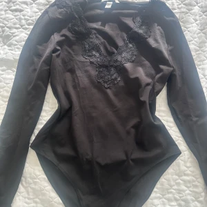 Svart body med spets - En svart body med spets från H&M. Den är i storlek M men passar även S. Den har en liten tråd som lossnat men de är knappt synligt. 💕☺️