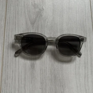 Grå transparenta solglasögon från CHIMI - Snygga solglasögon från CHIMI i transparent grå plast med mörka linser. Klassisk rundad form och stilren design. Kommer med originalfodral och låda. Använda få tals gånger inget fel alls nypris 1400kr säljs billigt vill bli av med dom! Nytt skick