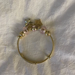 Armband - Säljer mitt guld isadora inspirerat armband med rosa och guld berlocker. Armbandet är inte använt och är då i nytt skick💗