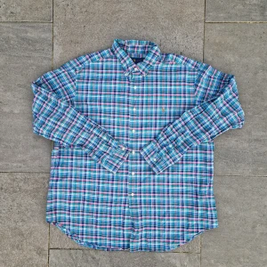 Ralph lauren skjorta -  Färg: Blå & Rosa  📏 Storlek: Extra Large (XL)  📐 Mått: Längd - 79cm Axelbredd - 51cm  ♻️ En långärmad blå & rosa Ralph lauren skjorta i storlek XL. Det står att den är I XXL men den är mer som XL. Väldigt bra skick, inga fläckar, hål eller defekter! Perfekt nu när det börjar bli varmare och sommaren kommer!☺️  👕 Material: 100% Bomull  #mensfashion #mensstyle #ralphlauren #classicstyle #buttondown #shirt #fashion #Vintage #Ralphlaurenskjorta