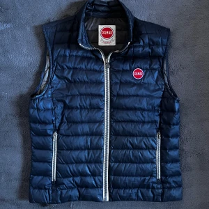 Colmar väst  - Snygg mörkblå dunväst från Colmar med quiltad design och två dragkedjefickor framtill som är perfekt nu till sommaren. Skick:9/10, storlek 50 så M/L. Pris går att diskutera✅