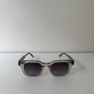 Gråa solglasögon med toning från Chimi Eyewear - Snygga solglasögon från Chimi med transparent båge och mörka fyrkantiga glas. Klassisk och stilren design.