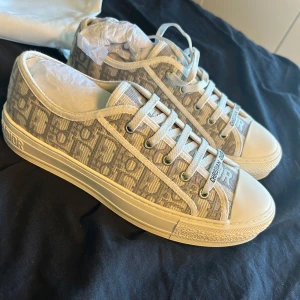 Gråvita sneakers från Christian Dior - Säljer nu dessa snygga Walk n Sneakers från Christian Dior. Innersulan är 25 cm. Dustbag, lapp och box medföljer! Hör gärna av er om ni har några frågor! Försöker svara så snabbt jag kan:) Köpta på Vinted för 8000! Använd gärna köp nu, postar samma dag. 