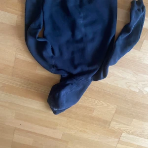 Svart Sailracing zip hoodie  - Säljer en svart zip hoodie från sail racing med dragkedja framtill och broderad logga på bröstet. Tröjan har långa ärmar, huva och är tillverkad i mjukt bomullsmaterial. Perfekt för en avslappnad stil. Original pris 800kr den är i storlek 150 men passar även xs