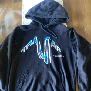 Svart hoodie med blått tryck - Säljer en svart trapstar hoodie i bra skick och den sitter riktigt bra. Max använt 5 gånger 