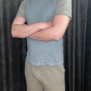 Blå och grå t-shirt från KV - Säljer en stilren t-shirt från KV i blått med gråa ärmar. T-shirten har en klassisk passform och är kortärmad, gamla modellen