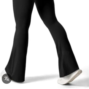 Svarta bootcut byxor med rynkdetalj - Svarta bootcut byxor med hög midja och snygg rynkdetalj framtill. Byxorna har en tight passform upptill och utsvängda ben, perfekta till sneakers eller boots.