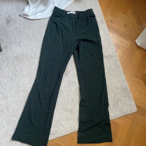 Mörkgröna kostymbyxor - Säljer ett par mörkgröna kostymbyxor i flare modell och klassisk passform. Inga defekter