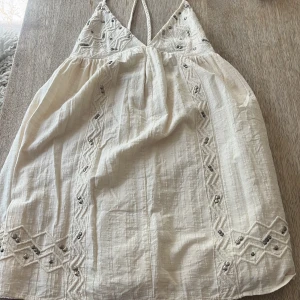 INTRESSEKOLL Söt sommar/strandklänning - Jättesöt sommar/strandklänning från Zara i storlek xs. Klänningen har en lös och avslappnad passform med halterneck-design och knyt vid ryggen och jättefina detaljer på framsidan. Den är i jättebra skick! Lägg prisförslag om du är intresserad 💝