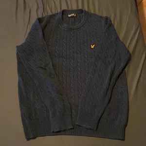 Mörkblå stickad tröja från Lyle & Scott - Pluss 39kr frakt Säljer en snygg mörkblå stickad tröja från Lyle & Scott. Den har ett klassiskt flätmönster och en gul logga på bröstet. Perfekt för kyliga dagar och passar både till vardags och lite finare tillfällen. Tröjan är i mycket bra skick.   Priset är självklart inte hugget i sten går att diskutera 