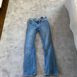 Blå jeansbyxor från Zara - Säljer ett par klassiska blå jeans från Zara i modell med raka ben och normal passform. Byxorna har fem fickor, knapp och dragkedja framtill samt snygga söm-detaljer. Perfekta till många olika stilar.