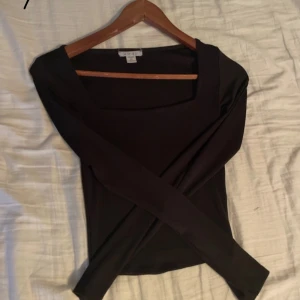 Svart långärmad topp från Urban Outfitters - Snygg svart långärmad topp från Urban Outfitters med fyrkantig halsringning. Perfekt för en stilren look. Passar bra till både jeans och kjol. 🖤