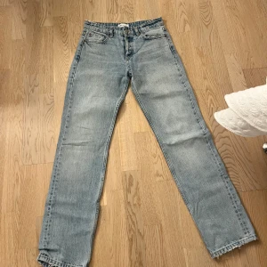Blå midwaist jeans från Zara - Blå midwaist jeans från Zara. De har en rak passform och lite slitningar i midja och benen i sin design! 