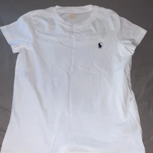 Polo Ralph Lauren T-Shirt - Polo Ralph Lauren tshirt i Vit med blå häst. Endast testad sprillans ny. Det står S men det sitter som XS. Finns även en i svart i min profil