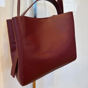 Vinröd axelväska från Gina Tricot - Snygg vinröd axelväska från Gina Tricot,  Väskan är använd en del men fortfarande i fint skick!