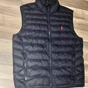 Mörkblå väst  Ralph Lauren - Säljer min helt oanvända väst. Köptes för nått år sen men är förstor för mig. Inga repor eller hål då den hängt i garderob hela tiden                           Storlek M