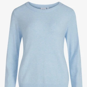 Ljusblå vågig  stickad tröja från vila - Säljer en ljusblå stickad tröja från vila. Tröjan har en klassisk rund halsringning och långa ärmar. Perfekt för kyligare dagar med sin mjuka och bekväma passform. Ribbstickade muddar vid ärmslut och nederkant ger en snygg finish.