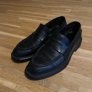 Vagabond Loafers - Snygga svarta loafers från Vagabond i skinn. Perfekta för en stilren look med klassisk design och bekväm passform. De har en elegant rem över vristen och en robust sula.
